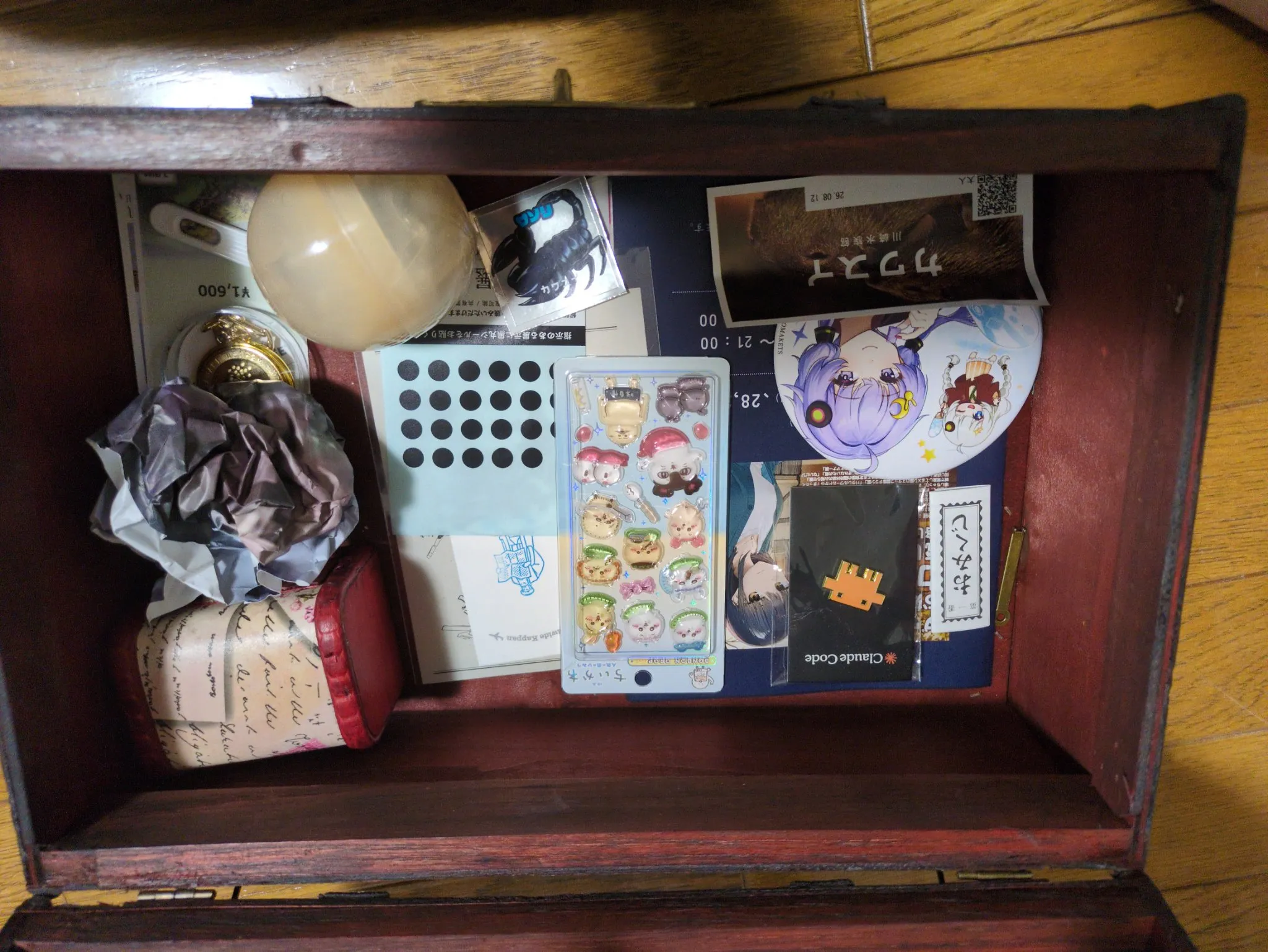 現実の木製の宝箱。栞やシール、缶バッジ、赤いミニ宝箱などを収めた8月28日の写真