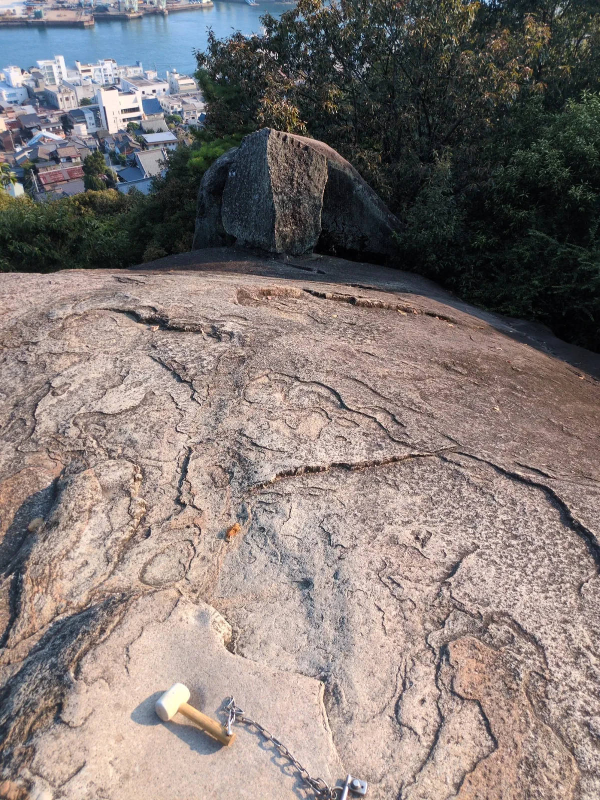 木槌の置かれた鼓岩。奥に尾道の町と海峡